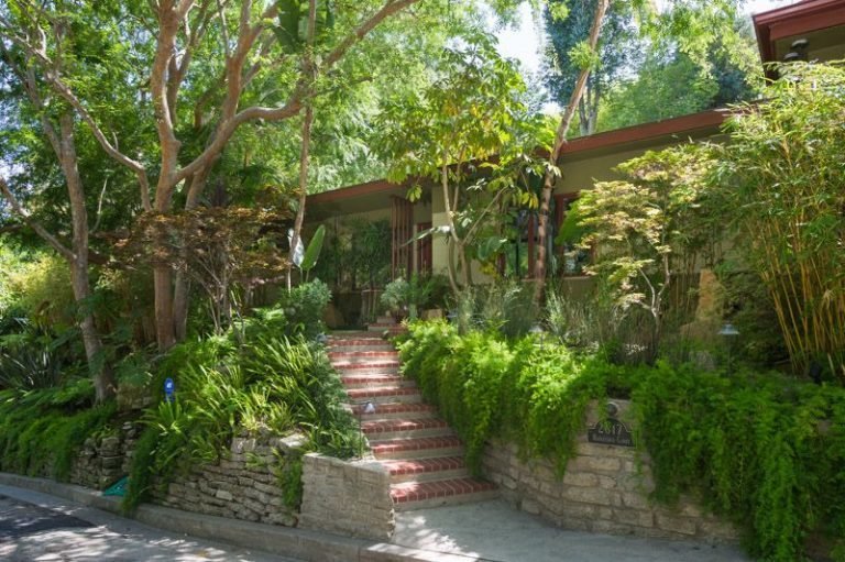 Brick stairs lead to the entrance of the midcentury abode.
