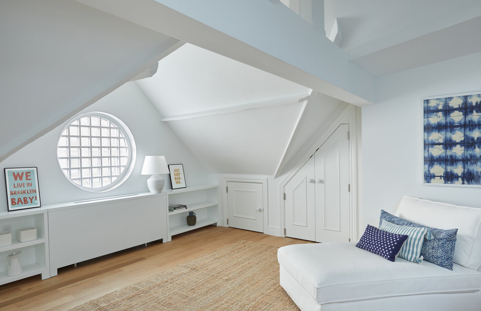 The third floor of 411 Vanderbilt features a fourth private bedroom with peaked ceilings, exposed beams, an en-suite bath and a beautiful round window.