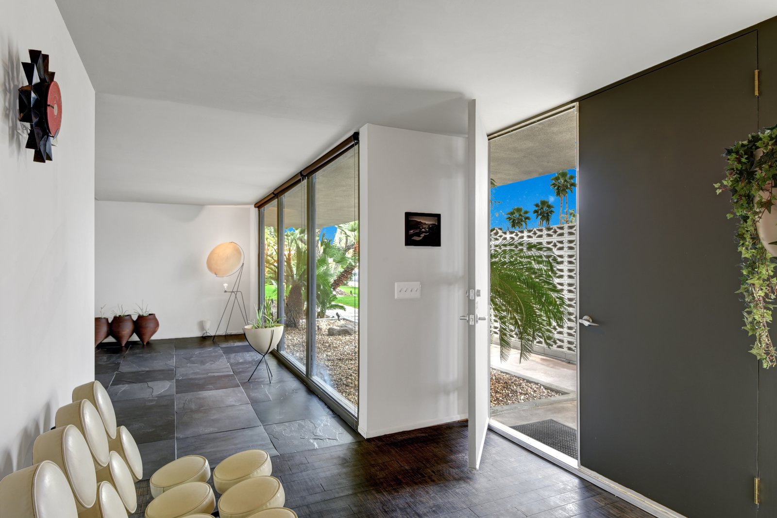 The entry hall has natural lighting thanks to floor-to-ceiling windows, and privacy thanks to an exterior privacy wall.