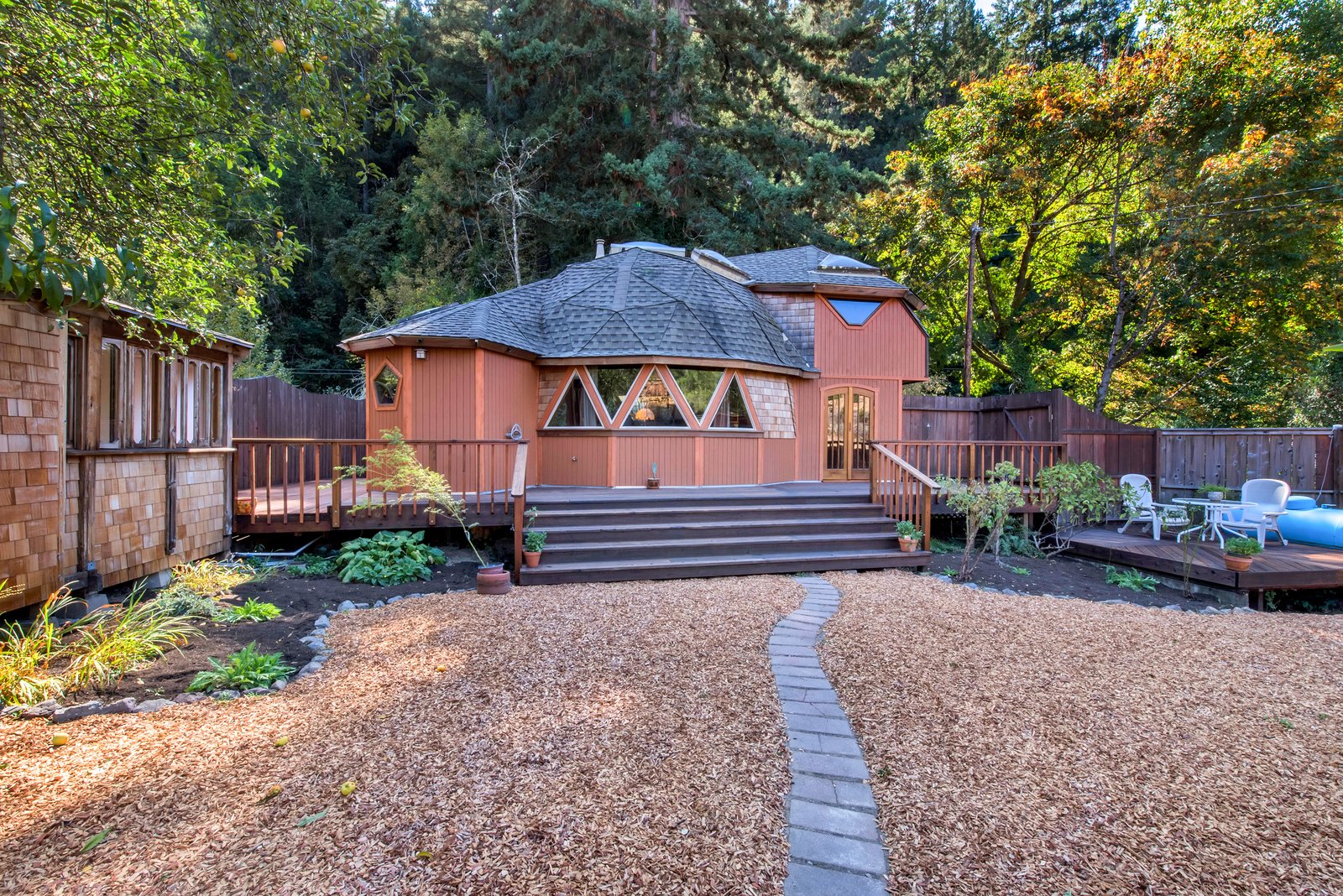 The property features not only the geodesic dome home, but also a large yard and two additional structures.