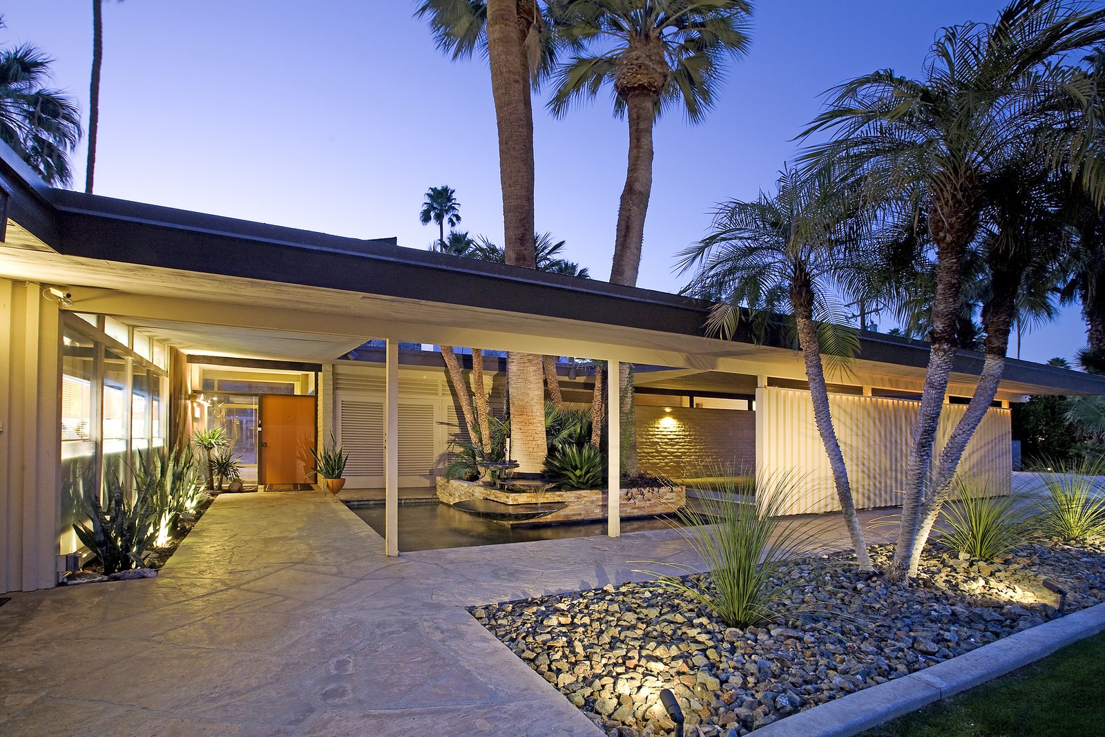 A fountain that spills into a palm sheltered pond at the entry.