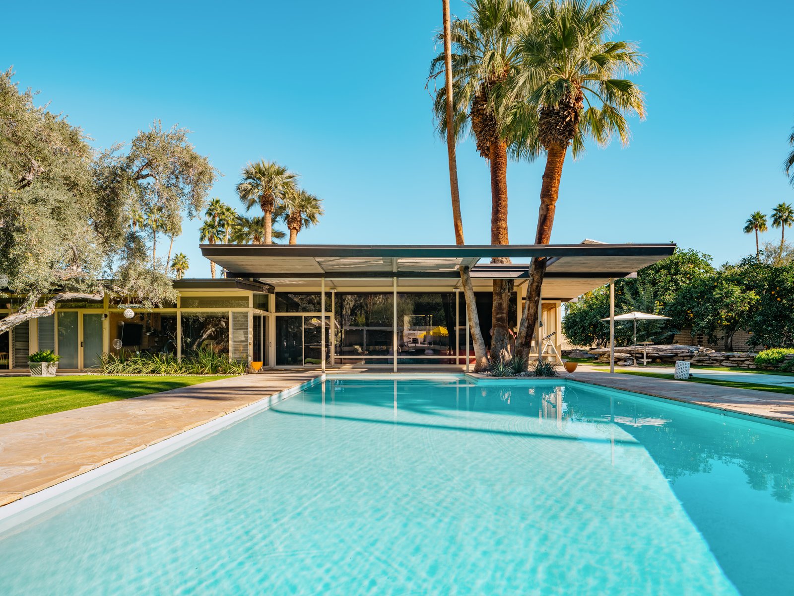 The large L-shaped estate looks out on a large pool and a luxurious outdoor entertaining area.