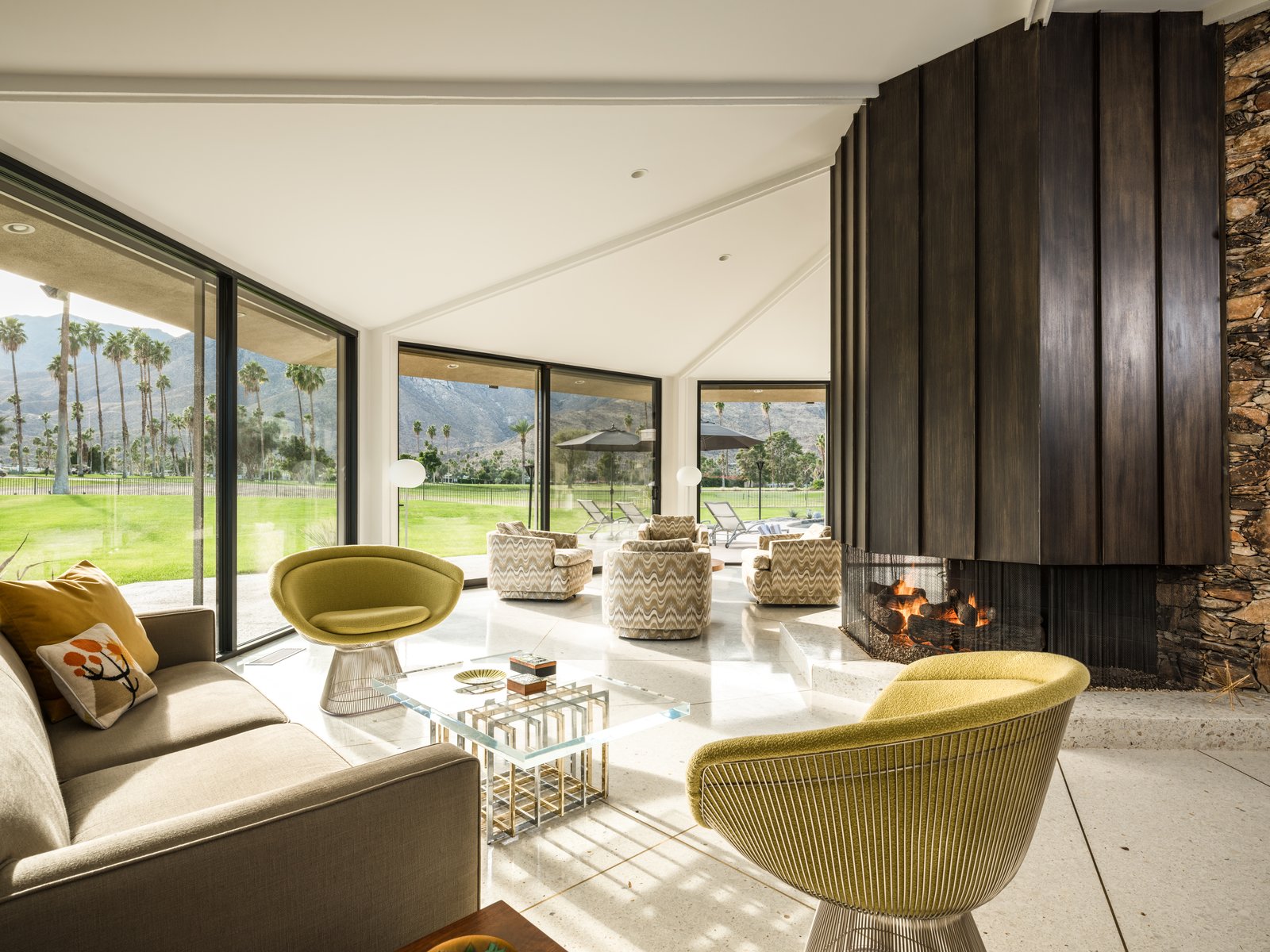Uninterrupted walls of glass in the living area offer views of the Indian Canyons Golf Course, the Disney fountain, and the picturesque mountain range.