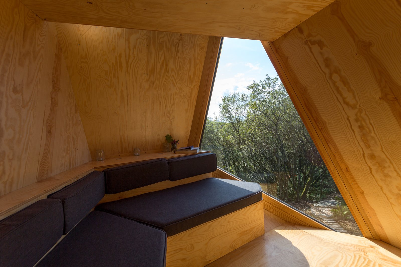 The petite interiors have a built-in sofa facing stunning views from the floor-to-ceiling windows.