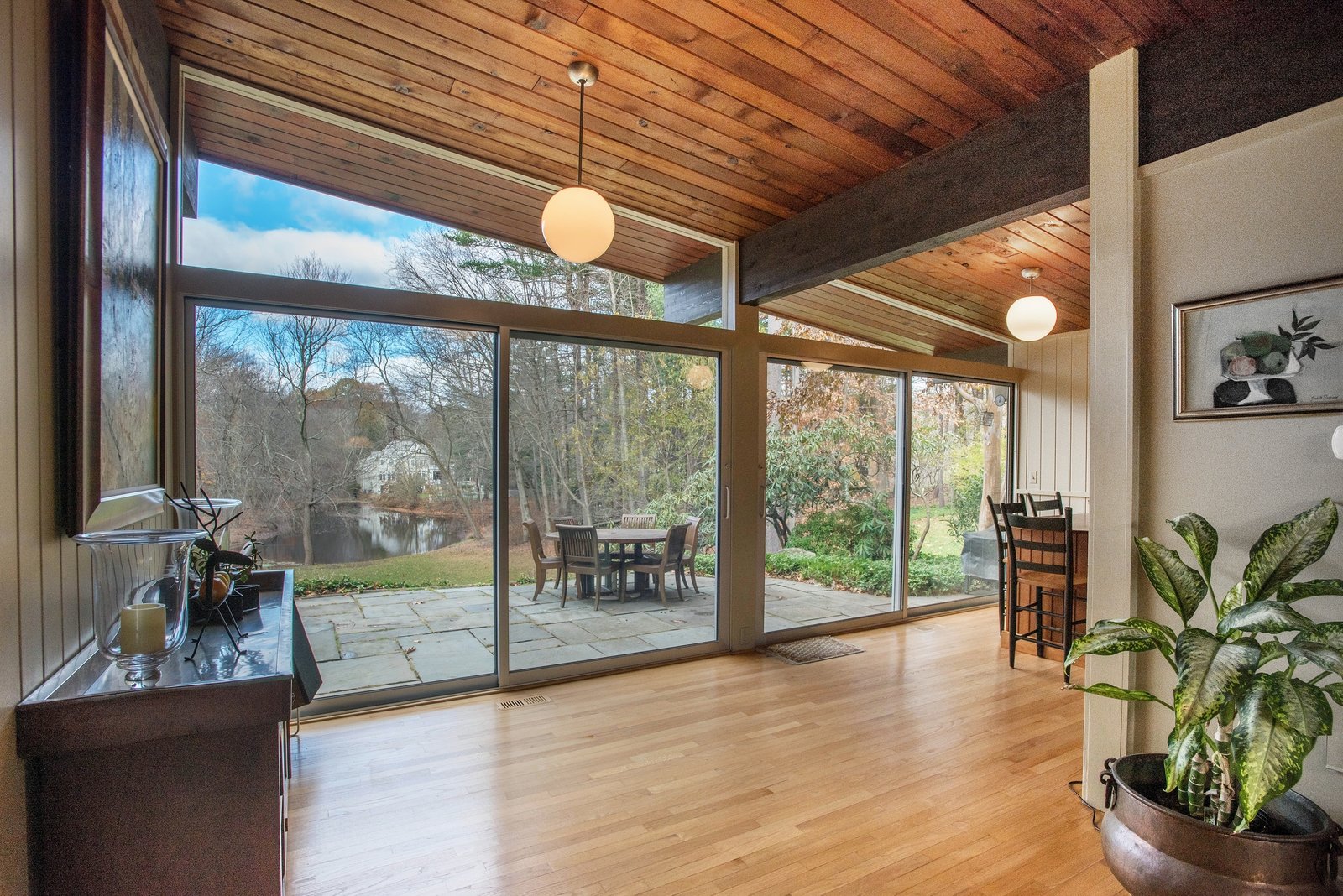Floor-to-ceiling wall of glass allows for expansive views of property and pond.