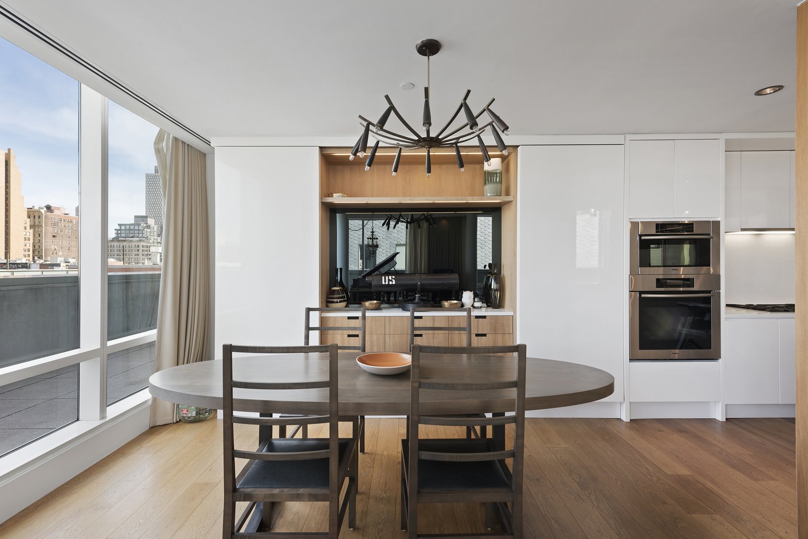 The living/dining area wraps around a central open kitchen and looks out on the wraparound terrace. The home features many state-of-the features such as a Creston electronic shade system throughout.