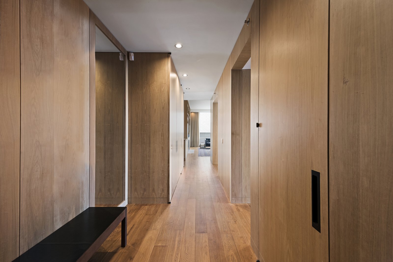 Wood-lined walls hold storage space and match the six-inch-wide plank oak flooring.