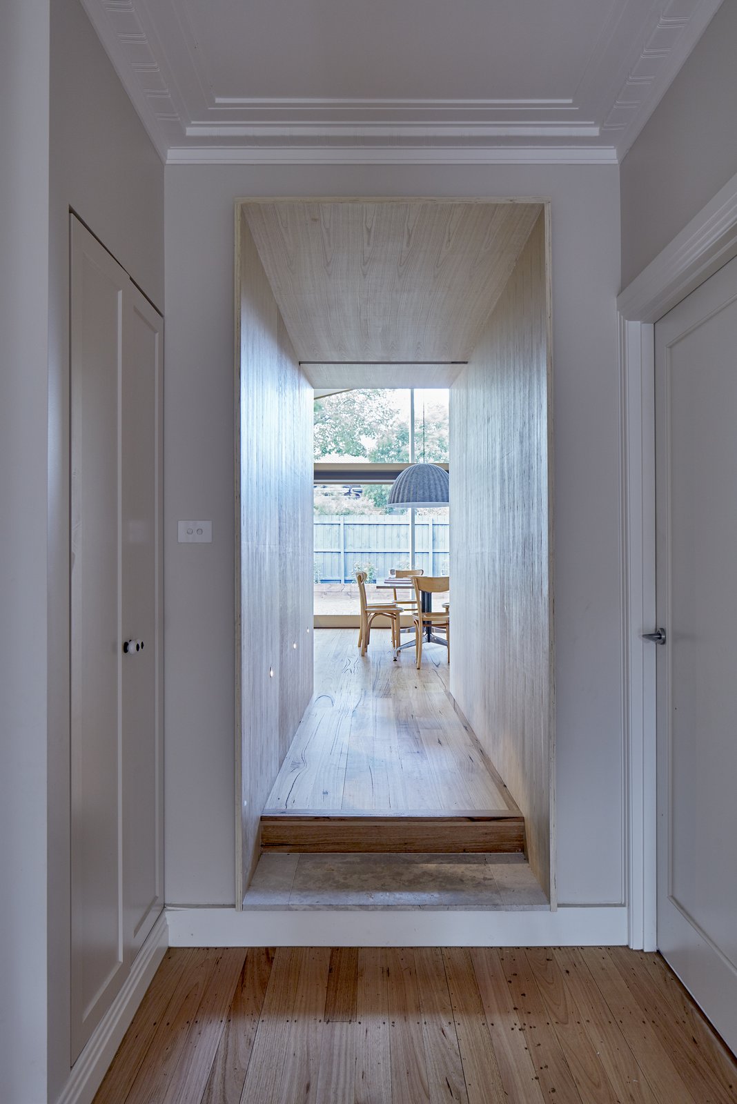 Spatial interconnectivity is facilitated through a plywood “chute” that connects and delineates the original house from the new addition.