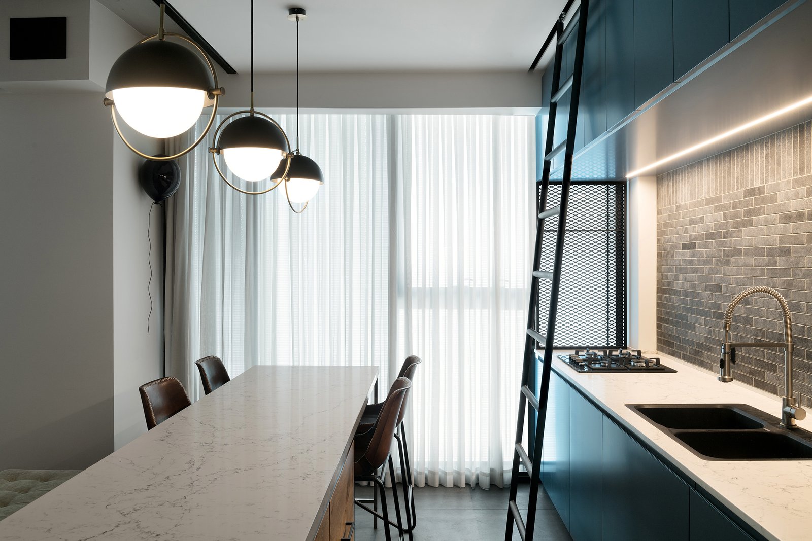 Surrounded by floor-to-ceiling windows on all sides, the material palette for the unit includes contemporary industrial touches such as iron, glass, and wood.