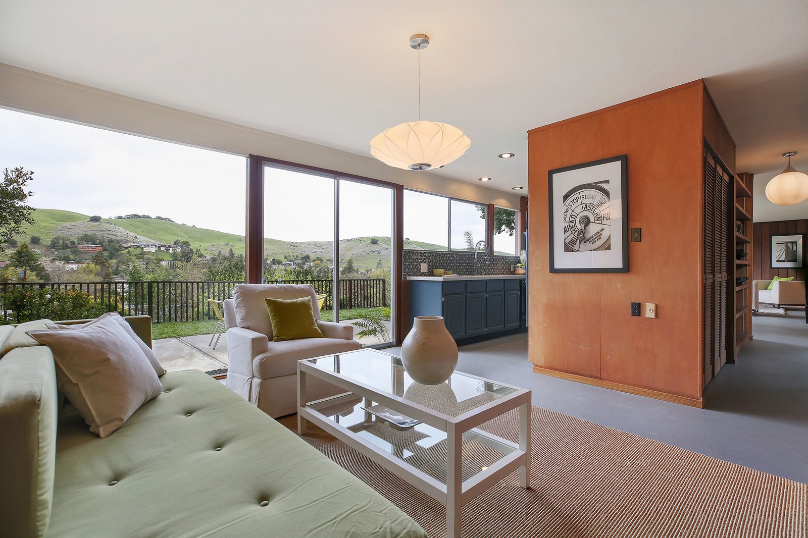 The family room has floor-to-ceiling windows which overlook the surrounding hilly landscape.