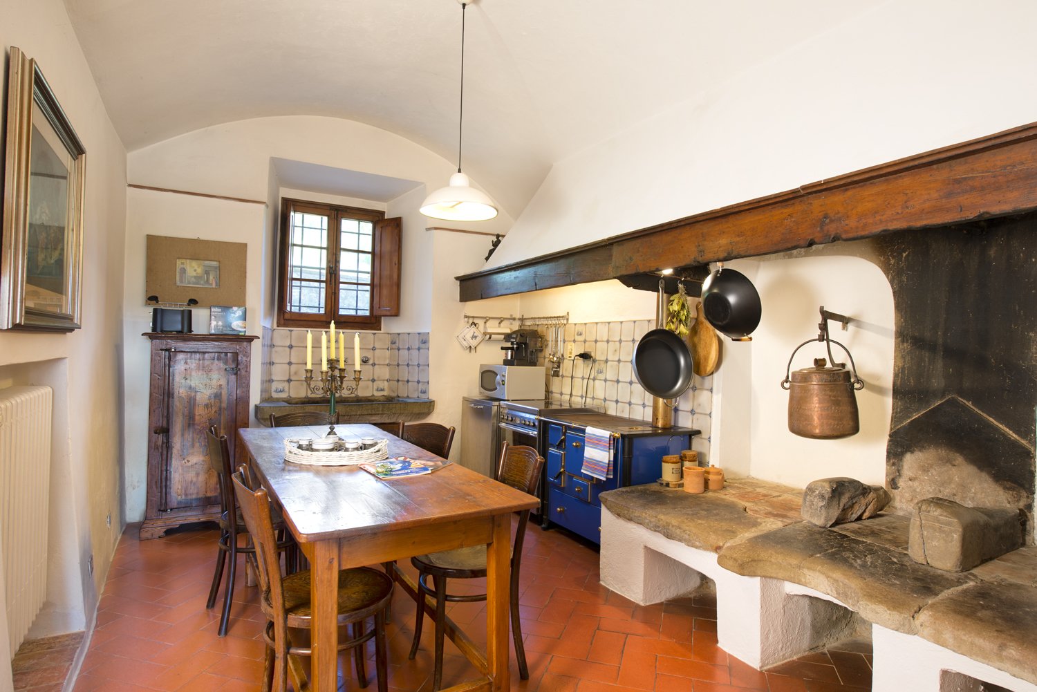 The kitchen features an original stone hearth and basin.