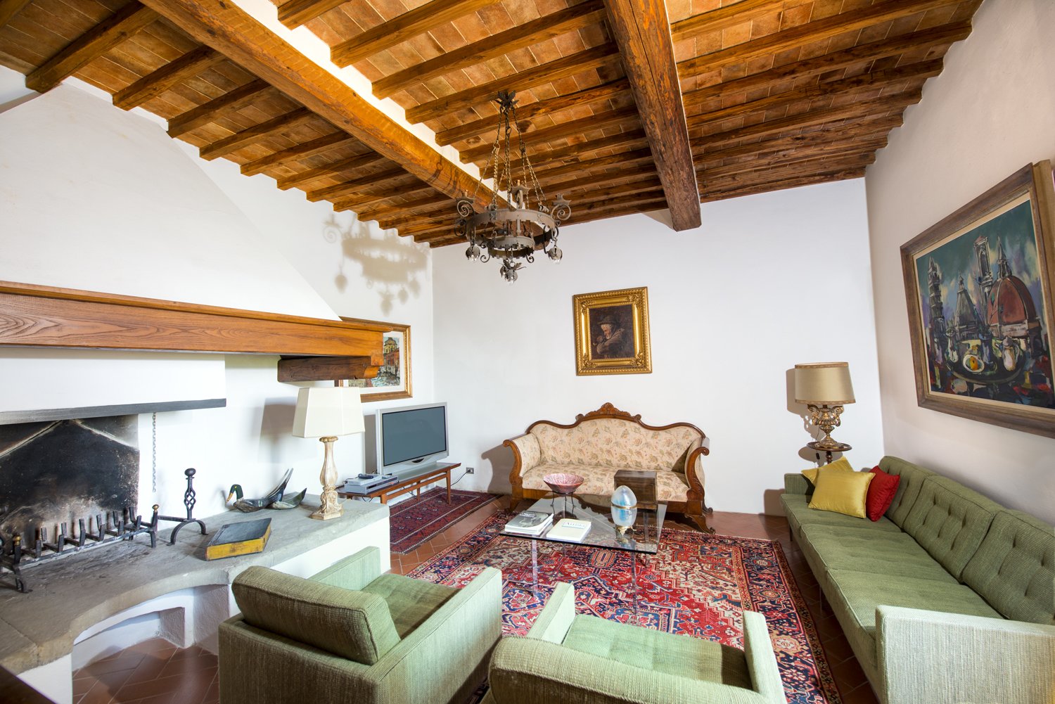 Beautiful beamed ceilings and another grand stone fireplace are the focal points of this sitting room.