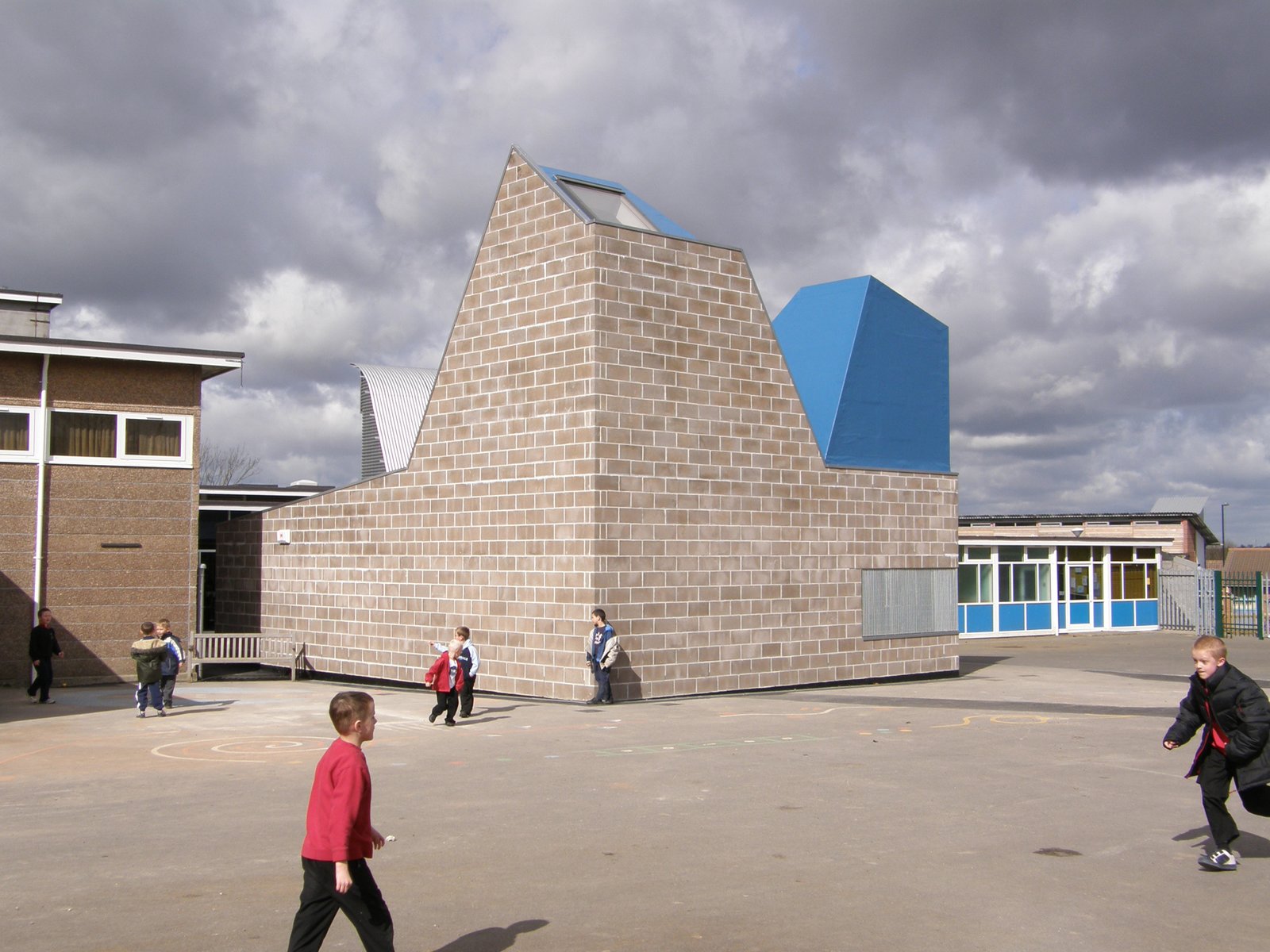 The building uses raw concrete block externally, and internally is finished with bare plywood, OSB and a varnished concrete screed.