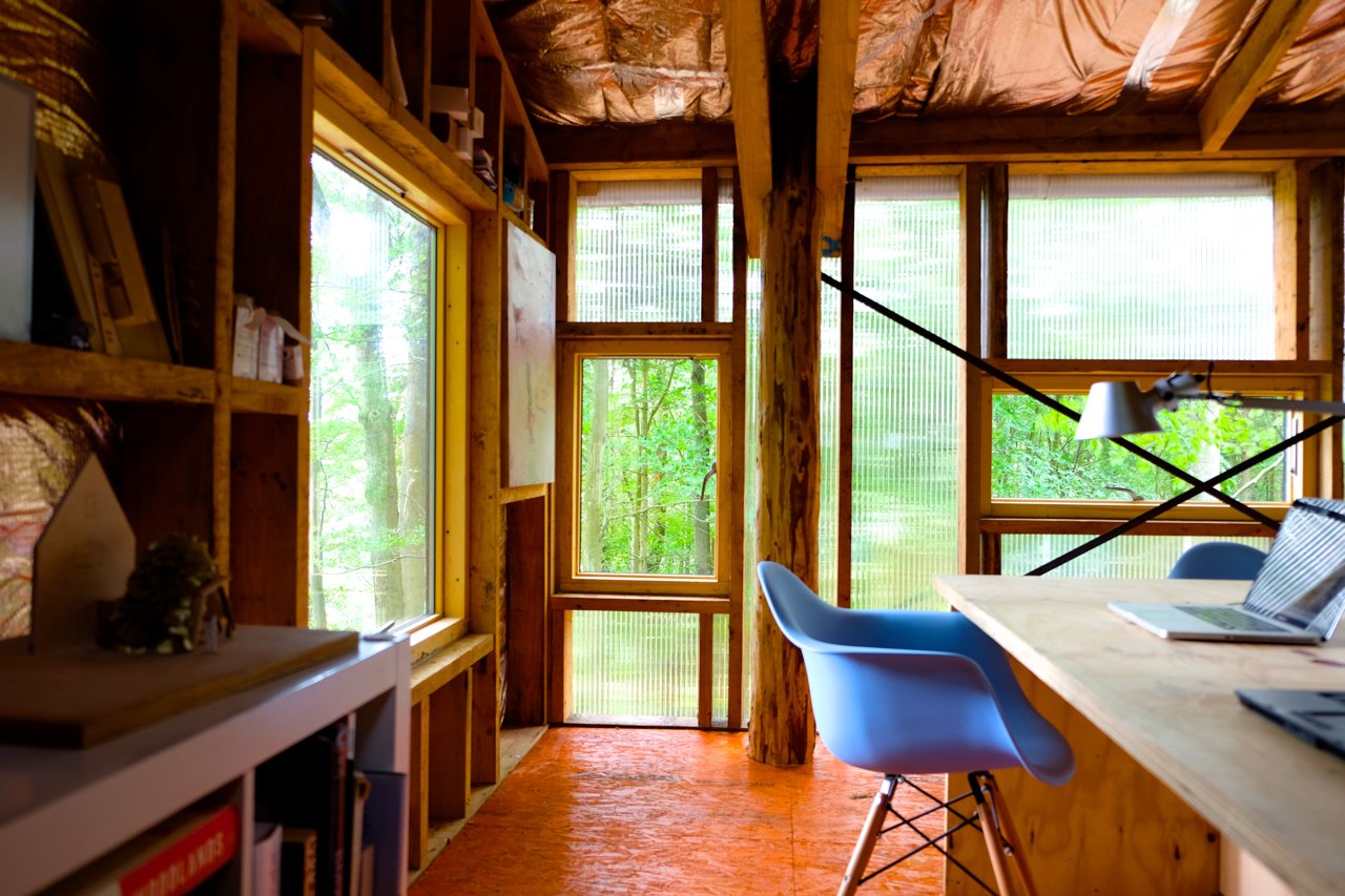 Visible Studio is heated by waste wood from the woodland, and water from the roof feeds into an attenuation pond that forms a natural habitat.