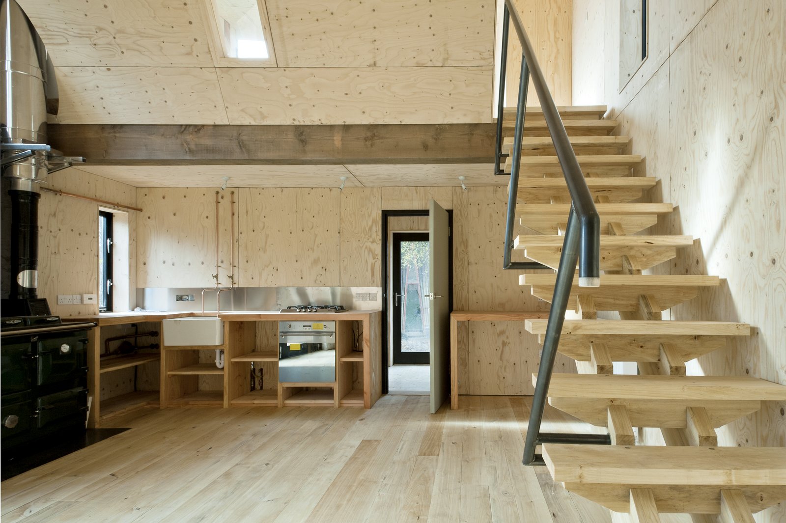 The construction process was super-efficient, even the joinery was manufactured on site. The kitchen (which uses exposed copper piping for taps) has chunky timber worktops, and the stairs use an innovative dry jointed system that gains strength as the timber dries. The handrail is made of mild steel bent piping, which was also welded on site.