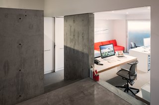 A Creative Agency with a Modern, Open Workspace - Photo 7 of 9 - Stairs leading to the garden-level suite are separated by a glass partition and pocket door.