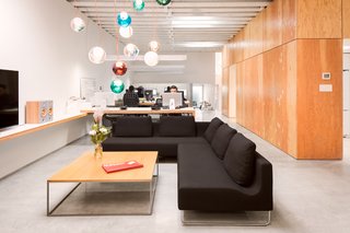 A Creative Agency with a Modern, Open Workspace - Photo 4 of 9 - A custom Bocci 28 copper chandelier hangs above a black wool sectional by Bensen.