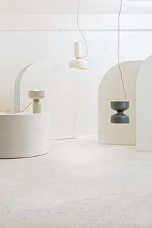 Studio Visit: The Work of ANDlight - Photo 3 of 10 - Spotlight Volumes — Design, Lukas Peet<br><br>A pendant light with two shades, made from a combination of four possible shade types. Each end has an LED globe bulb to illuminate both above and below. The electrical cord acts as an additional design feature, wrapping around the midsection and gently curving towards the ceiling. 