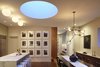 This photo shows the changing color temperature of the drum skylight. Here at dusk when the light turns a beautiful blue. The photo also highlights our use of multiple styles of architectural lighting: tape-in recessed LED downlight, surface mounted and pendent fixtures combine to create a warm modern environment. Photo of White Street Residence modern home