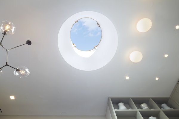 Looking up into the 5' wide drum skylight in the White Street Residence - remote controlled synchronized linear actuators open and close the skylight which allowed us to meet the NYC Code for legal light and air. A beautiful Lindsey Adelman Branch chandelier is on the left and Flos Glo Ball fixtures paired with USAI Bevel trimless fixtures are on the right. Photo 16 of White Street Residence modern home