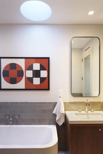 A detail photo of the master bath in the penthouse addition. Here highlighting some of our favorites - tile from Heath Ceramics, plumbing fittings by Dornbracht, bathtub and sink by Duravit and an Arne Jacobsen hand towel ring by Vola. The medicine cabinet was custom made to our specifications and has a cold rolled blackened steel frame. Photo 6 of White Street Residence modern home