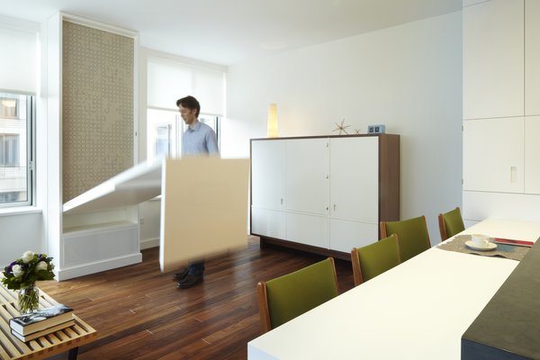 An action photo of the fold down table - highlighting a few of our favorites, walnut flooring @lv_wood, Hella Jongerius fabric @maharamstudio and a custom bureau built by our go to furniture builder Stephen Iino. The table build-out also houses a subwoofer speaker connected to the AV equipment in the bureau. All wiring is concealed running in a routed channel behind removable wood base. Photo 8 of Riverside Residence modern home