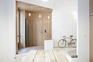 Filled with crisp lines and textural contrast, the interior plan widens the small apartment by setting it apart, creating alcoves, living spaces, and sculptural dimension within the open white spaces.