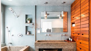 Own a Piece of Hollywood History for $1.995M - Photo 6 of 9 - Luxurious amenities outfit the master bathroom, where wood shelving provides a warm counterpoint to blue tiles and a concrete sink and tub.