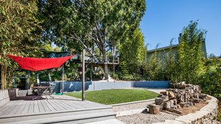 Own a Piece of Hollywood History for $1.995M - Photo 8 of 9 - The backyard features a treehouse, wrapped around a robust ficus tree, and a rope swing over a grassy lawn.