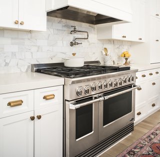 An Interior Designer's Streamlined Kitchen - Photo 2 of 7 - Dual Flow Burners deliver rapid, even heating that can reach up to 23,500 BTU, and the cooktop offers a total of up to 116,000 BTU with burners simmering at 140 degrees. A power griddle reaches 18,000 BTU. The dials offer precise control with LED halos that turn white, orange, and red to indicate heating up, preheated, and self-cleaning modes, respectively.