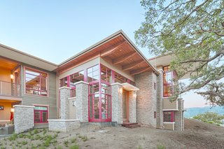 An Architectural Feat in Silicon Valley Tames a Rocky Landscape - Photo 8 of 8 - The home rises and falls across 7 levels to accommodate the contours of the site. While the exterior dry stacked stone, cedar siding, and wood trim echo the natural landscape, the red windows lend contrast and definition to the structure.