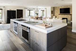 The gas and induction cooktop, along with the two ovens below, face the bar seating at the kitchen island, allowing Lefebvre to interact with his guests while preparing meals. 