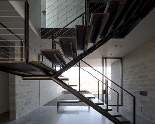 This Sleek Desert Home Seems to Melt Into the Sky - Photo 4 of 12 - The staircase remains open in form, helping to visually knit the entryway's garden into the living space while providing a structural focus.