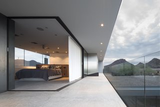 This Sleek Desert Home Seems to Melt Into the Sky - Photo 9 of 12 - A corner Multi-Slide Door transitions the master bedroom onto the patio, allowing the Staabs to sleep en plein air.