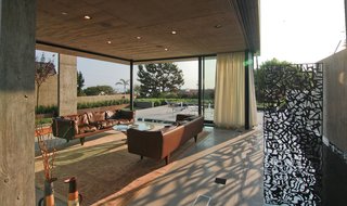 This Architect's Home Embraces Oceanfront Views - Photo 5 of 7 - Multi-Slide Doors by Western Window Systems retract and allow the living room to enjoy the offshore breeze. The pool extends along one side, allowing the homeowners to feel as though they are floating over water.
