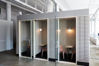 Pink Muuto Visu Chairs invite employees into the phone rooms while Dome Sconces by Allied Maker provide gentle light. The felt-wrapped rooms with bleached plywood slats are one of Murphy's favorite features. "It's a nice nod to the Japanese inspiration that originally helped get the game off the ground," says Murphy.