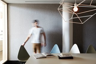 A large meeting room, equipped with Drop Chairs by Fritz Hansen and a sculptural Spica Light by Iacoli & McAllister, seats 14.