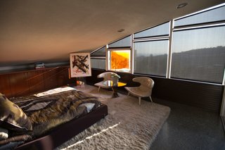The guest bedroom also enjoys its own arched view with a colored glass panel.