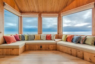 Settle in the Celebrated Sea Ranch For Under $2.9M - Photo 4 of 11 - Banquette seating in the living room places guests at the edge of a panoramic view. A 1970s chessboard hides under one of the cushions.