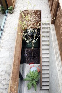 Weathered Steel Clads a $4.7M Home Near London’s Kew Gardens - Photo 9 of 10 - A sunken courtyard acts like a light well illuminating the basement, which is currently set up as a playroom, though it can be renovated to become additional bedrooms, an office, a self-contained studio, or even a lap pool.