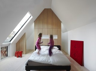 Weathered Steel Clads a $4.7M Home Near London’s Kew Gardens - Photo 7 of 10 - Large windows, partially screened by perforated steel, make for an airy master bedroom, which exhibits more bespoke oak cabinetry.