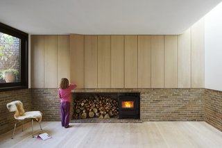 Weathered Steel Clads a $4.7M Home Near London’s Kew Gardens - Photo 3 of 10 - Bespoke oak cabinetry, produced by an on-site joinery workshop, conceals storage in the living room. A curved ceiling softens the space.