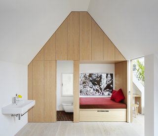 Weathered Steel Clads a $4.7M Home Near London’s Kew Gardens - Photo 8 of 10 - An en-suite bathroom, walk-in closet, and window seat complete the bedroom. A bridge leads to a guest room, a family bathroom, and two linked children's bedrooms.