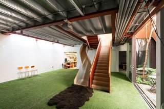 Weathered Steel Clads a $4.7M Home Near London’s Kew Gardens - Photo 10 of 10 - Alternative routes, levels, and spaces create a landscape of delight in the home—like this slide that leads from the living room to the basement.