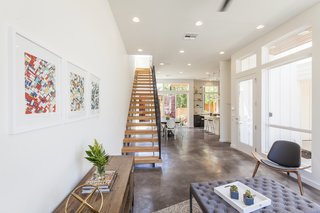 Ship Shape: An Austin Home With a Shipping Container Addition Asks $499K - Photo 1 of 9 - A stained concrete floor gleams throughout the first floor. "The staircase is a real showstopper," says Rios, "connecting to the industrial steel of the containers, but warmed by wooden beams."