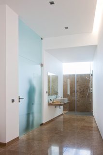The en-suite bathroom has a large bathtub, shower, and pre-installation for a steam or sauna room.