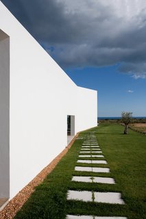 The shape of the home flares towards the front of the lot, expanding from private to public space.