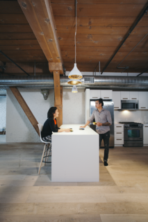 The kitchen features IKEA cabinets and a peninsular bar that encourages mingling between areas.