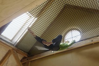 A hammock hung between beams, accessible from the mezzanine, provides a sunny spot to lounge.