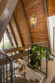 A Modified A-Frame Overlooking Los Angeles Starts at $699K - Photo 2 of 9 - Upon entering, the foyer offers dramatic views of the San Gabriel Mountains straight ahead, framed by the wooden beams of the steeply pitched roof. On either side of the foyer are the master suite and second bedroom.